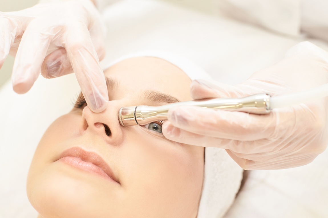 Micro dermbration cosmetology treatment. Facial diamond peeling. Anti acne procedure. Woman and doctor hands. Medical hadware
